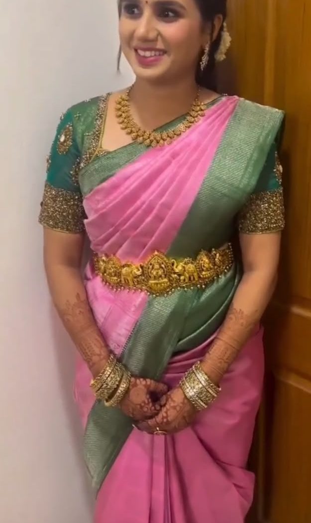 Bride in pink and green silk saree with gold oddiyanam