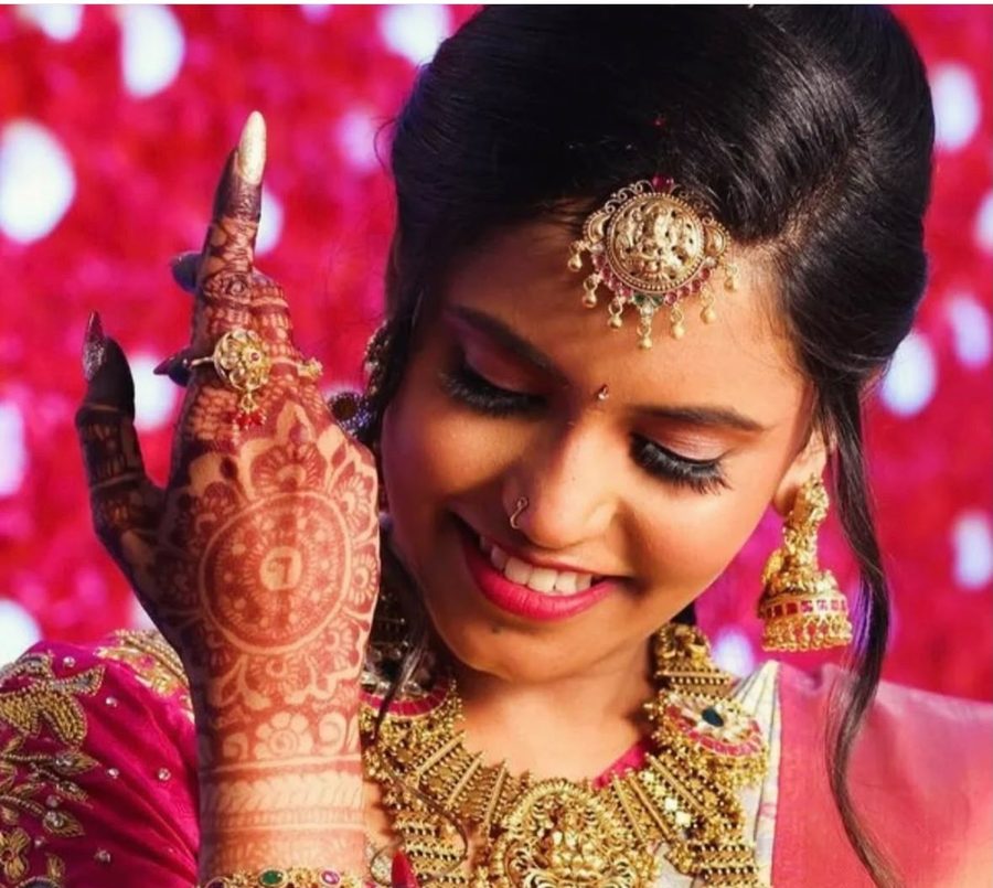 Bride with mehendi and Lakshmi maang tikka